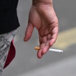 homme avec une cigarette à la main